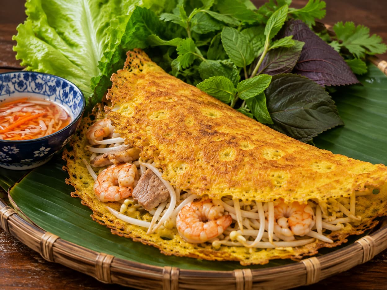 Crispy Vietnamese bánh xèo with pork, shrimp, bean sprouts, lettuce and fresh herbs