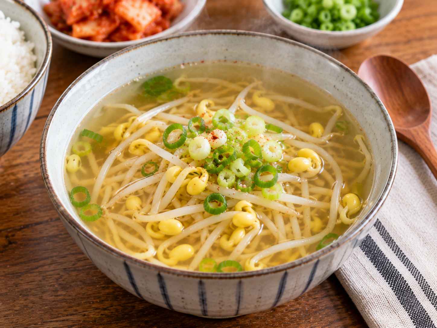 Bowl of Korean bean sprout soup (kongnamul guk) with soybean sprouts, green onion, and clear savory broth